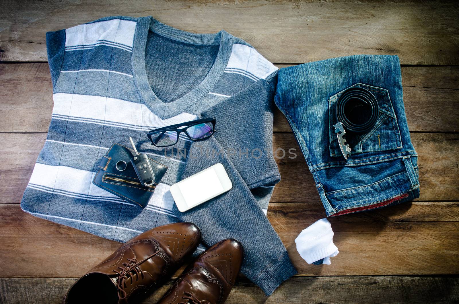 Sweaters, jeans, socks, shoes, belts, wallets, sunglasses, ready for travel.