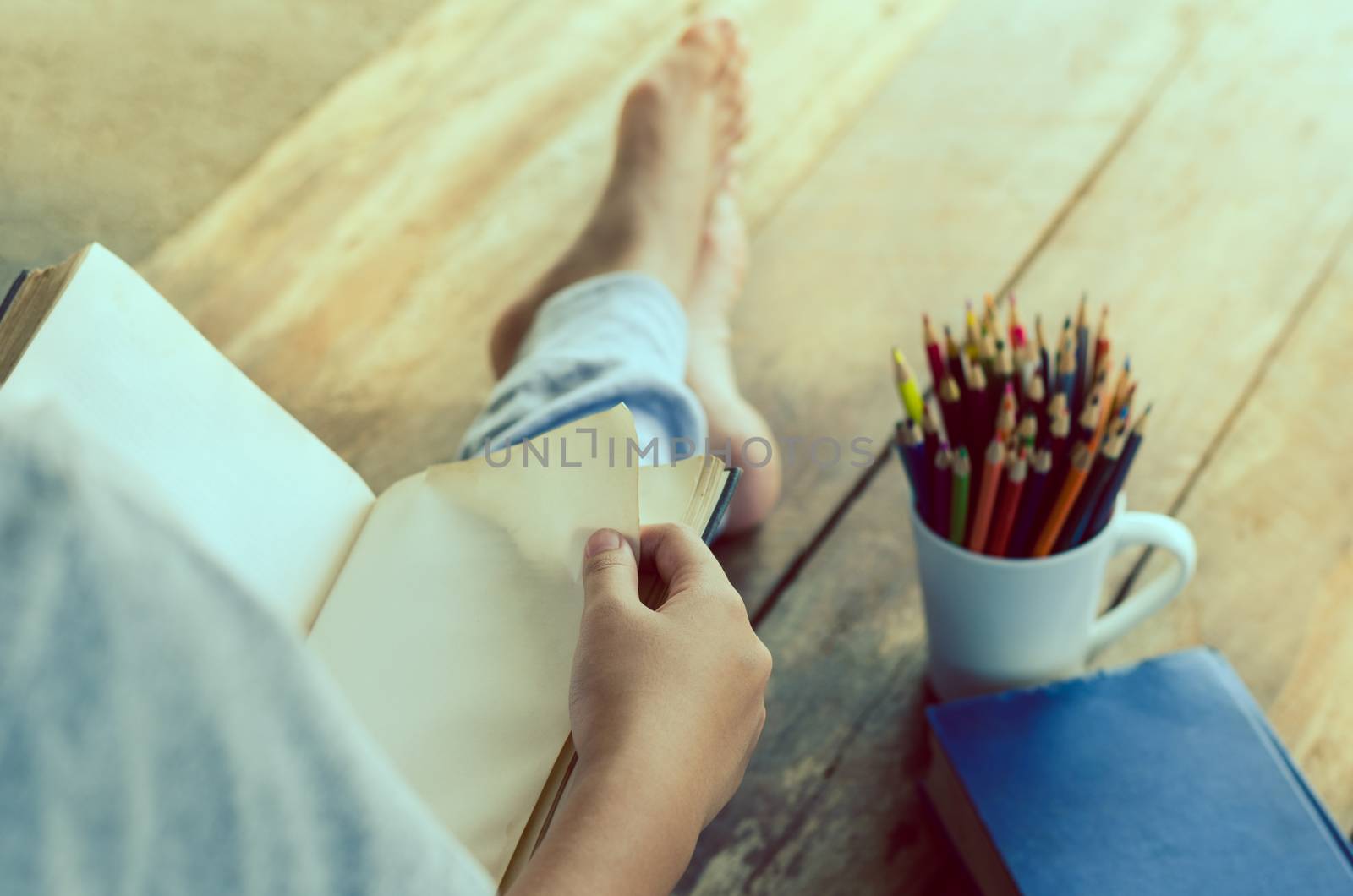 reading book on wooden floor with book and color pencil -tone vintage