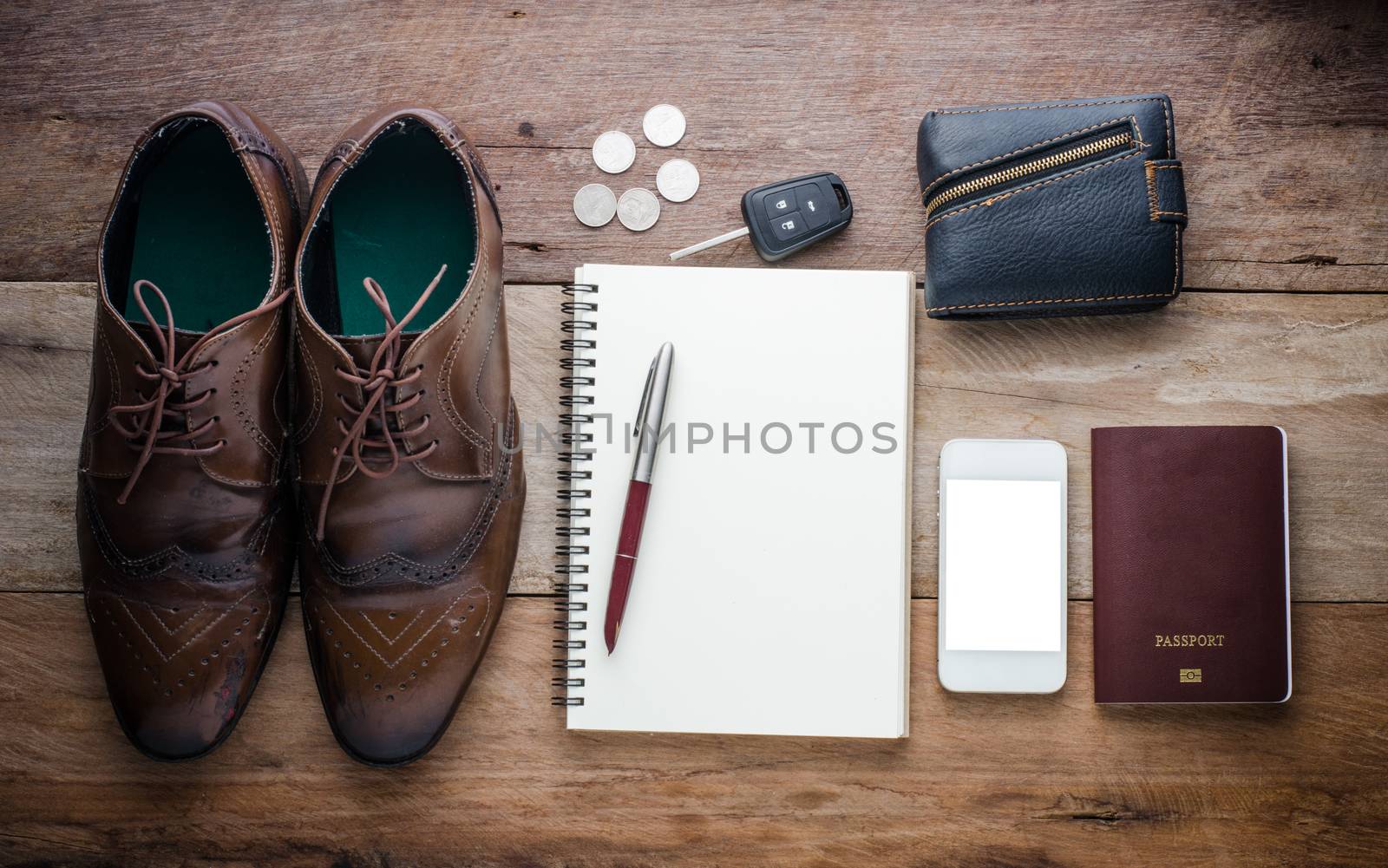 Accessories, passport, wallet and car keys, coins, shoes, notebooks, and pens for the trip.