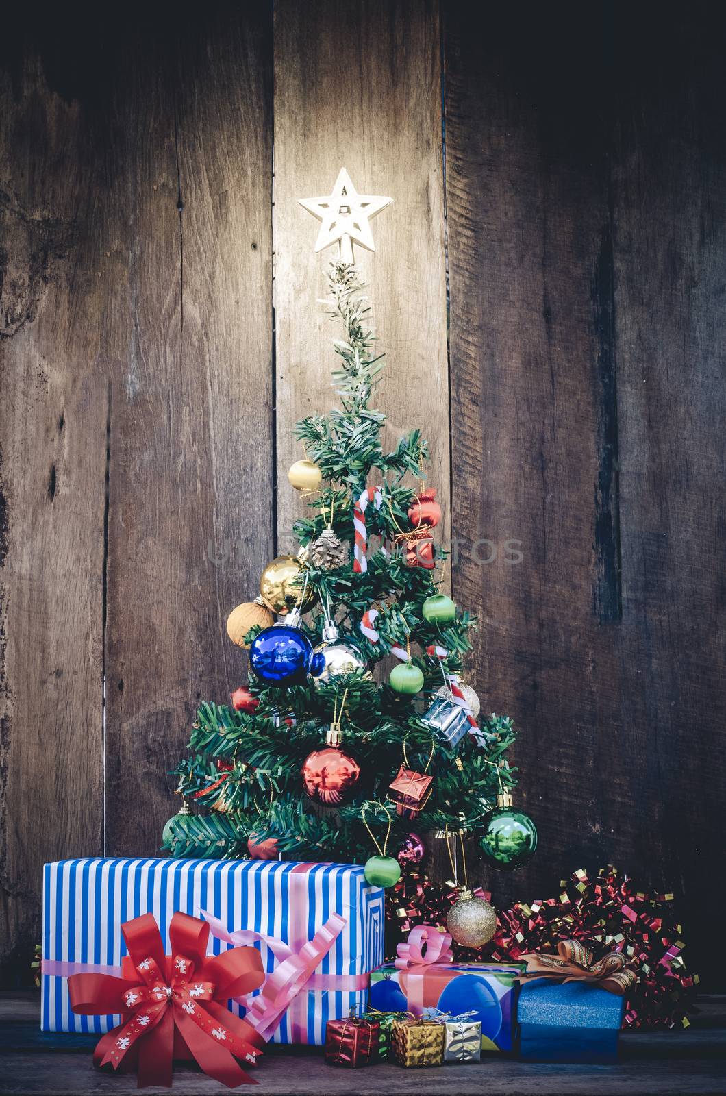 Christmas tree with colorful ornaments a wood background by photobyphotoboy