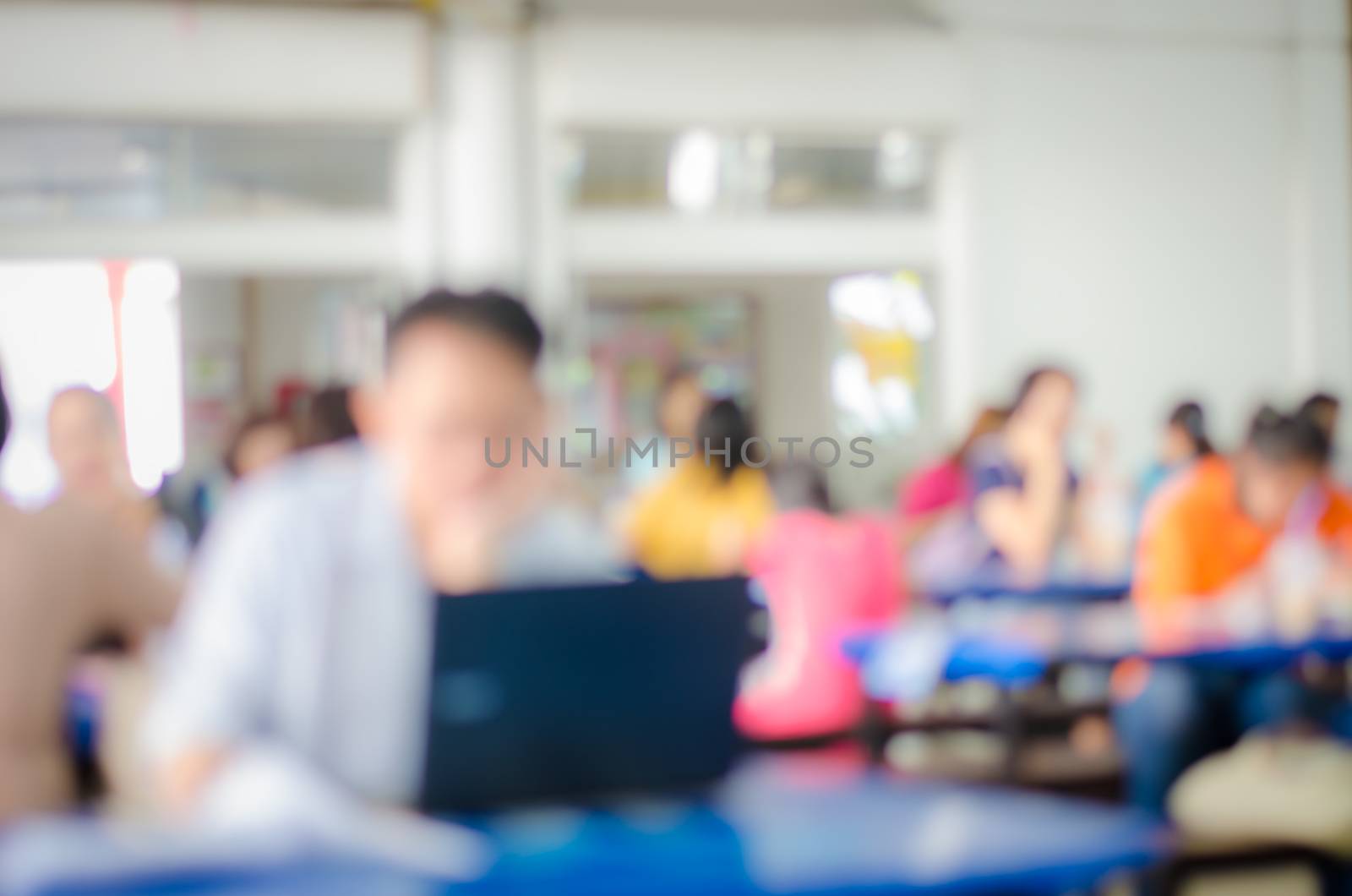 Blur image people enjoy different activities between meals in the cafeteria.