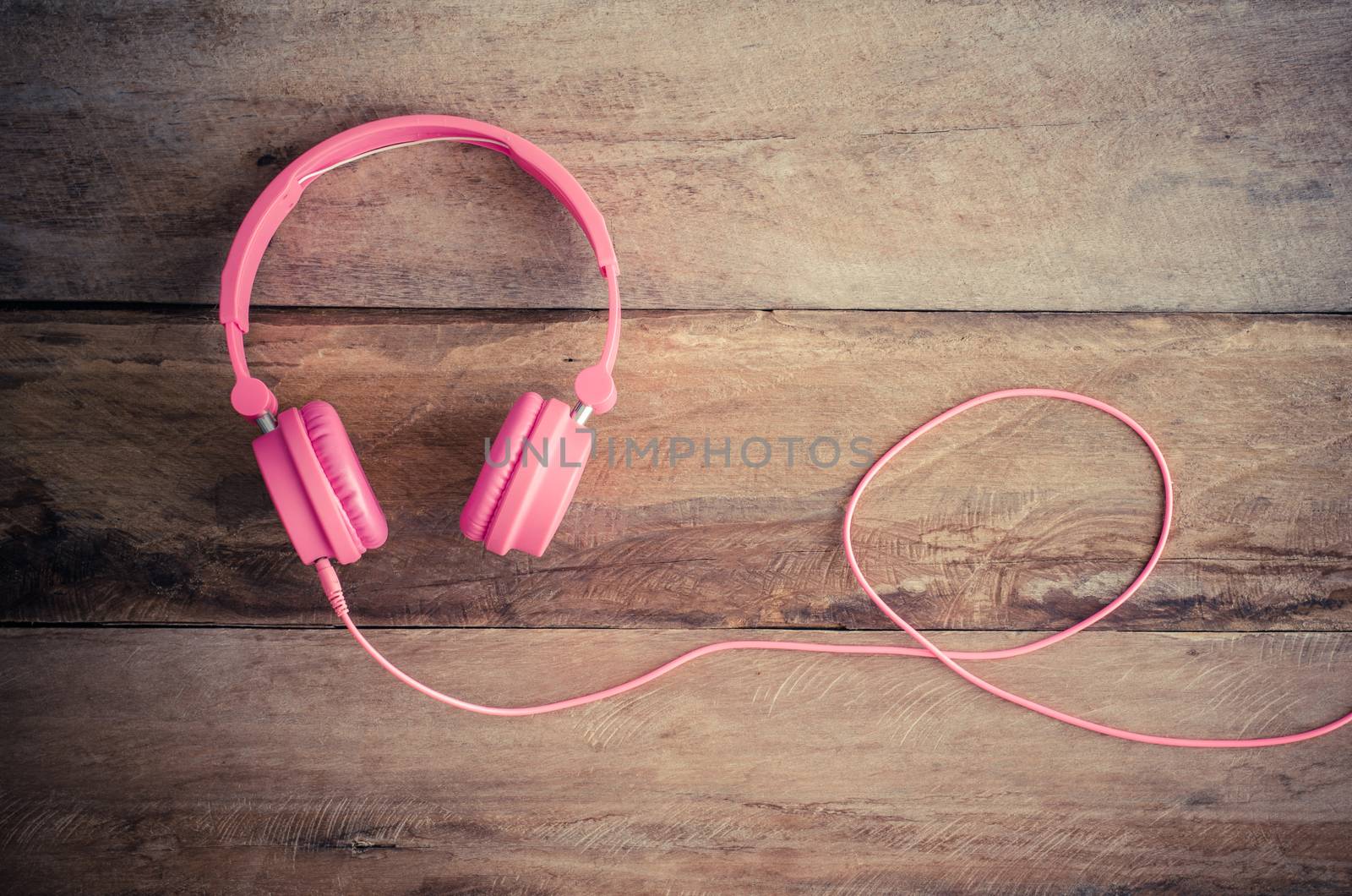 Pink headphones on the wooden floor