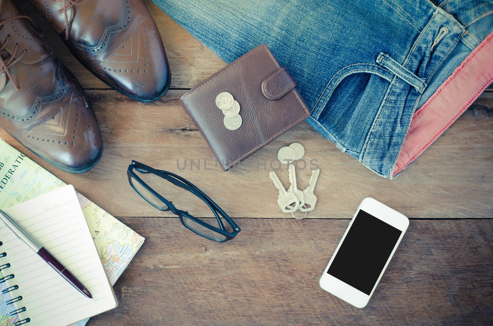 accessories jeans smart devices earphones hat glasses on a wooden floor.
