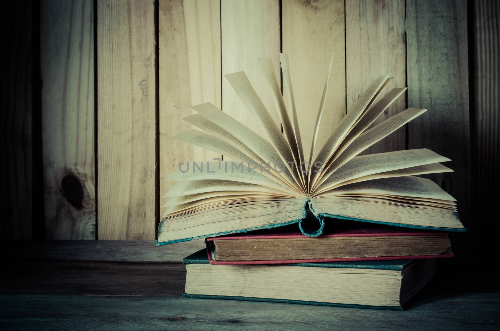 Old book open on a wooden floor - tone vintage