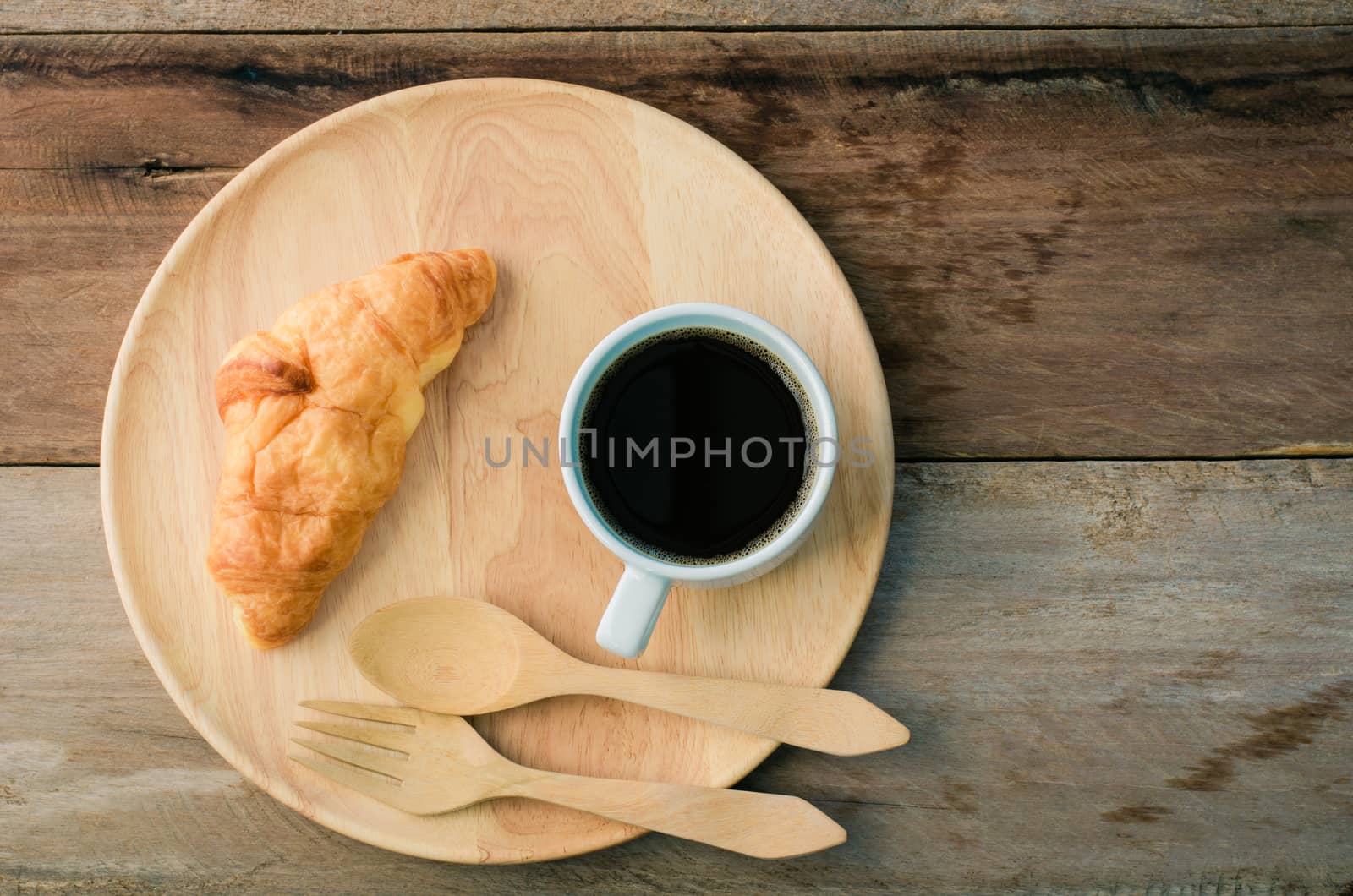 Croissants coffee spoon and fork wood on the wooden table - tone vintage
