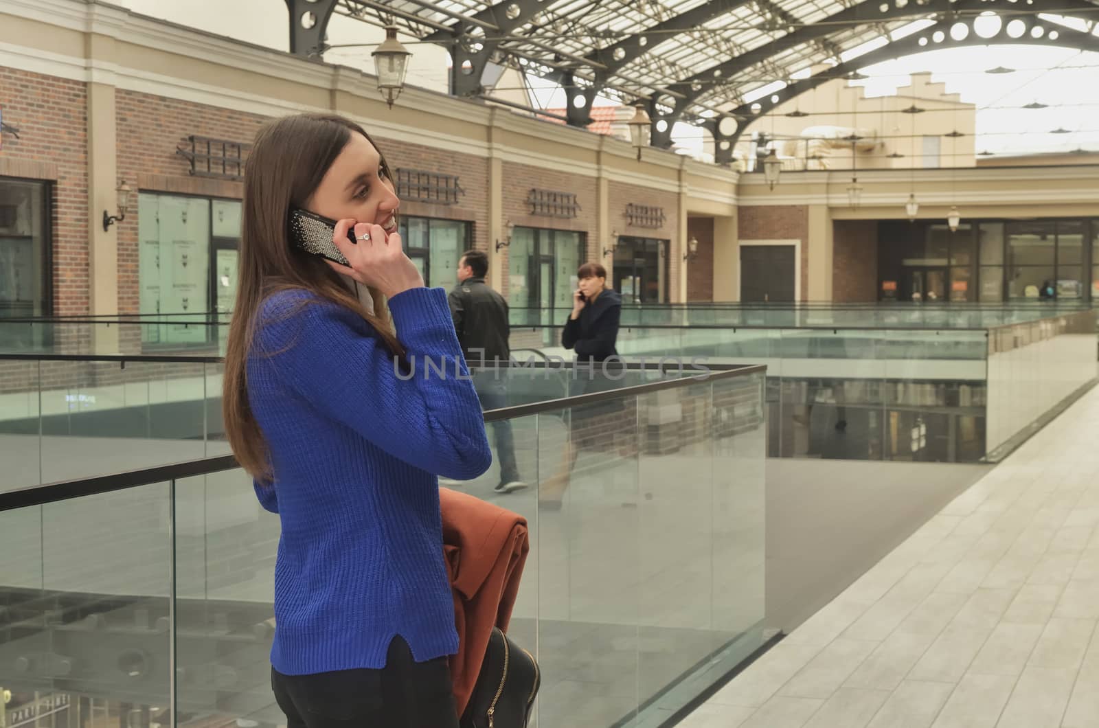 A beautiful girl walking the shopping center and talking on the phone