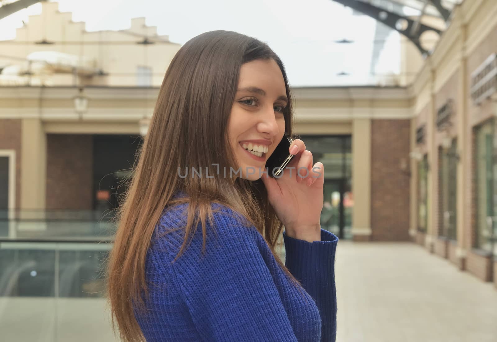 Portrait of a beautiful girl talking on the phone, walking shopping mall
