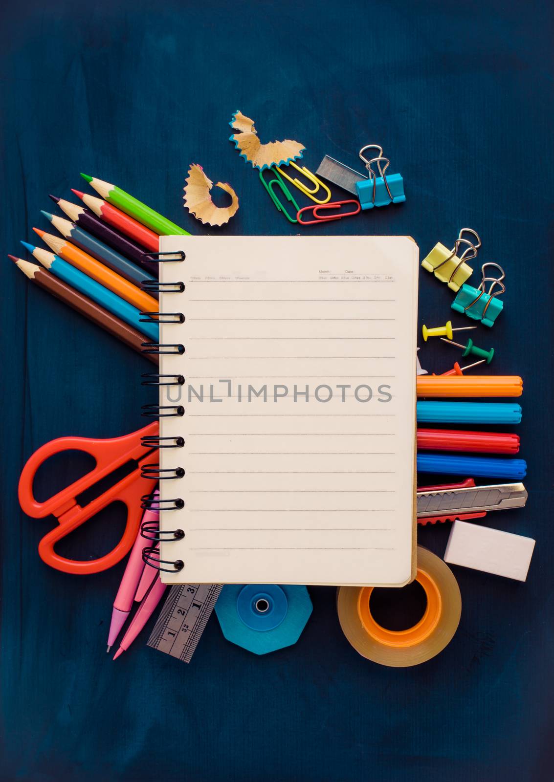 School supplies placed on a background blackboard concept ready for school. by photobyphotoboy