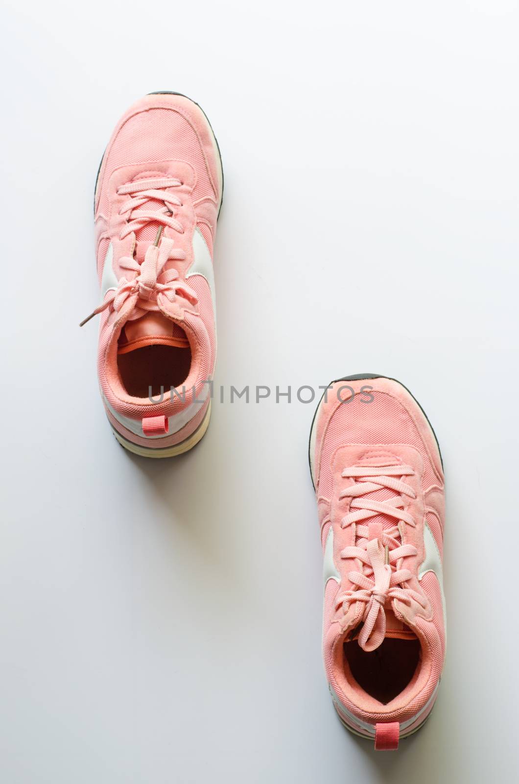 Pink sneakers on a white background, ready for jogging. by photobyphotoboy