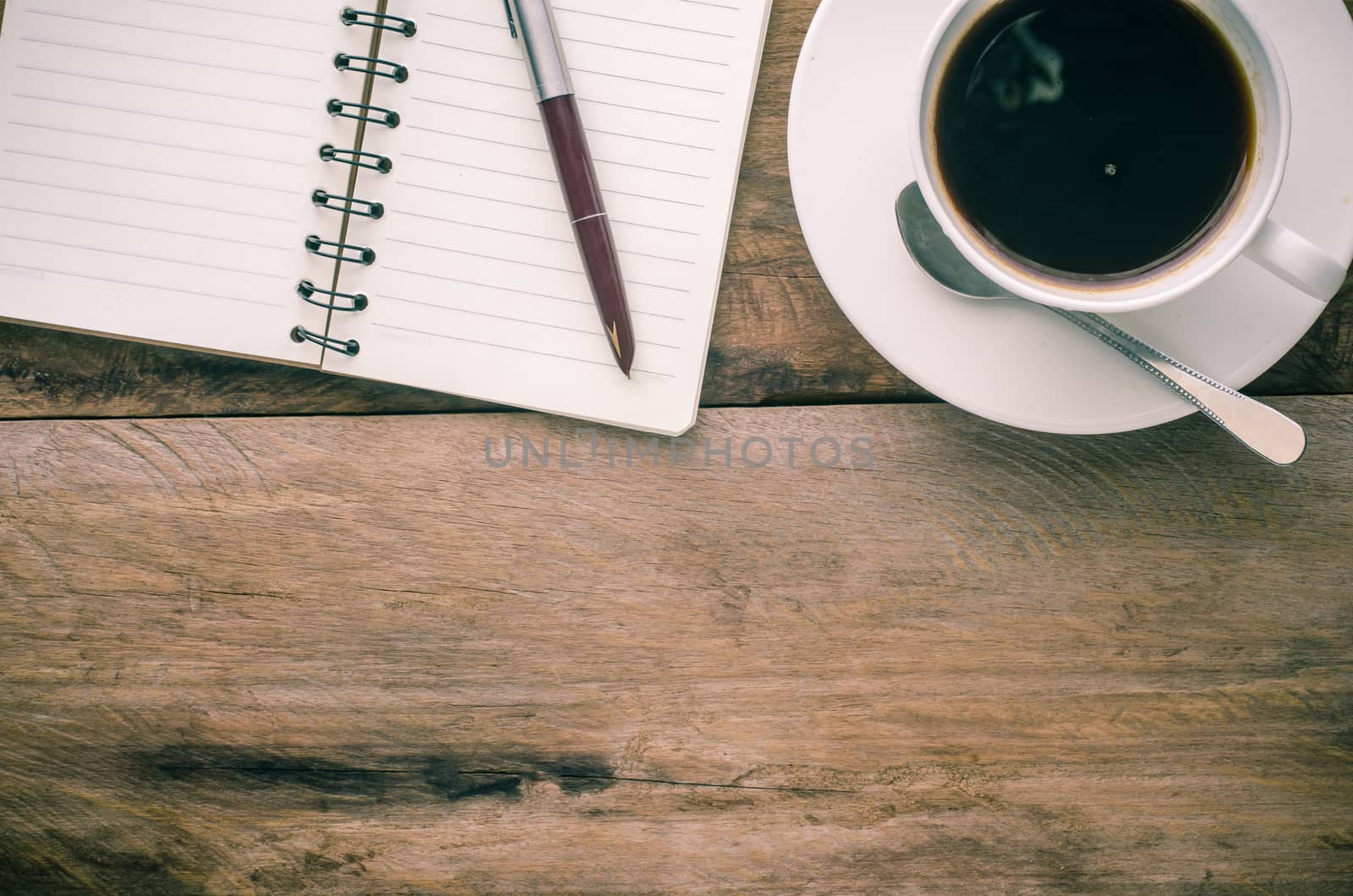 Notebook pen and cup of coffee on wood by photobyphotoboy