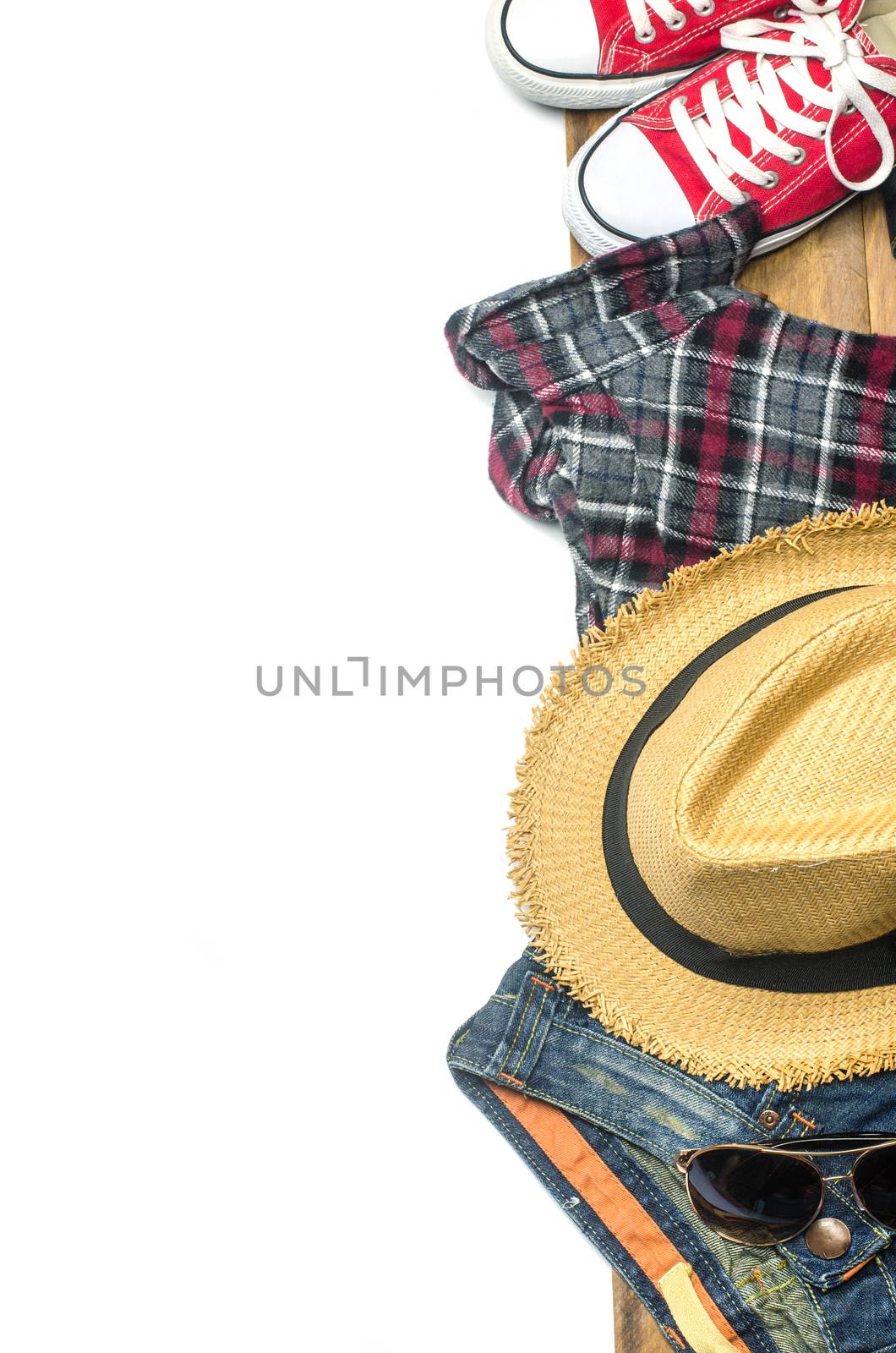 Apparel, equipment and tools for travel on a wooden floor with a white space in the background to add text to it.