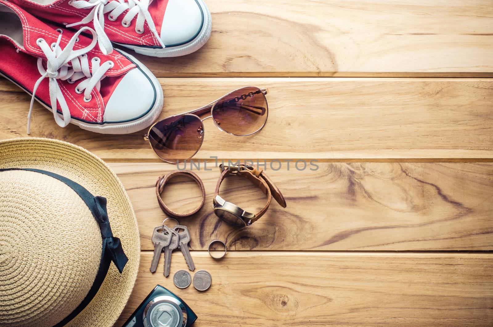 Clothing and accessories for travel on wood floor by photobyphotoboy