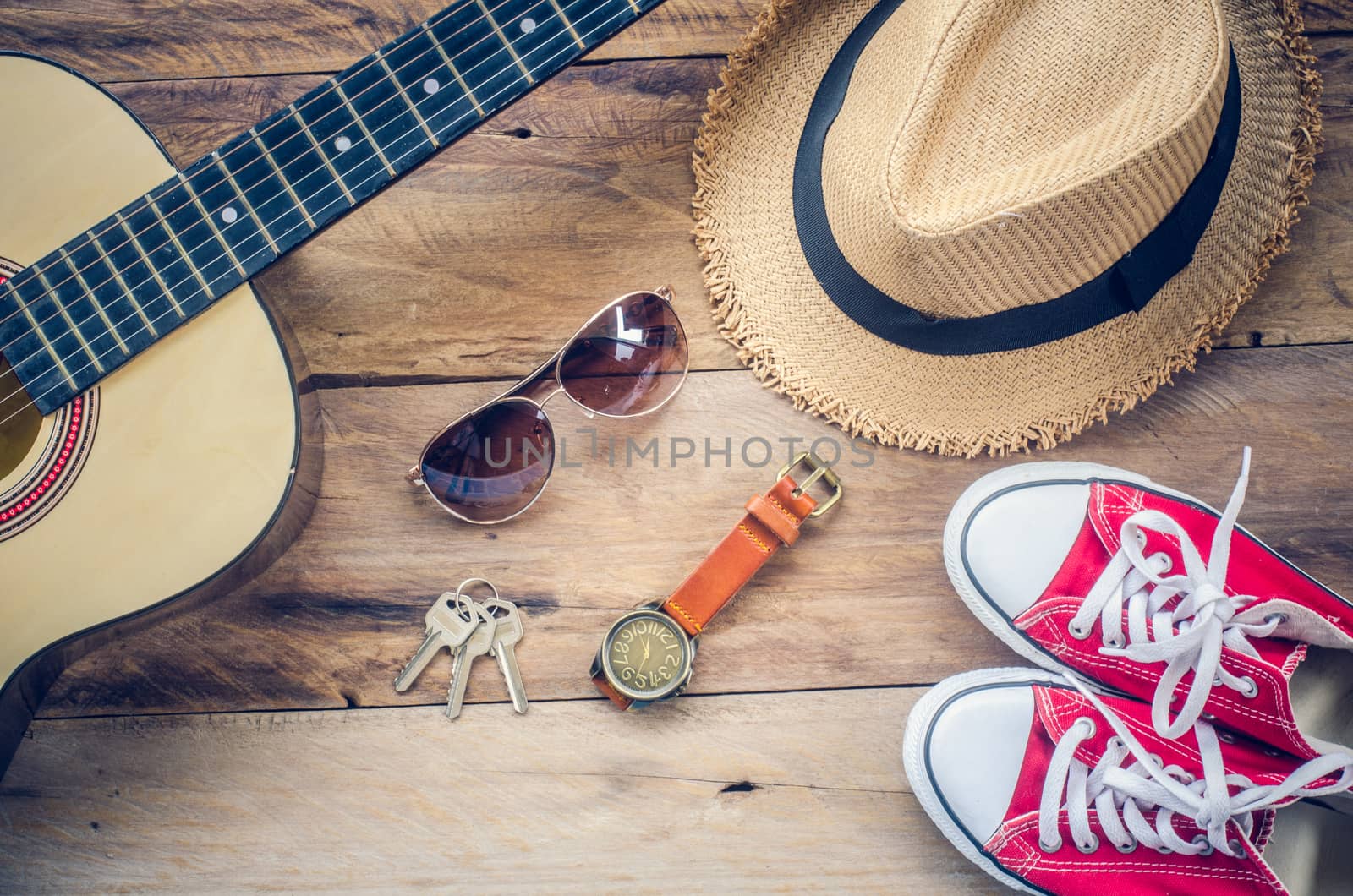 Guitar, sneakers, sunglasses, hats, watches, apparel accessories for men on the wooden floor.