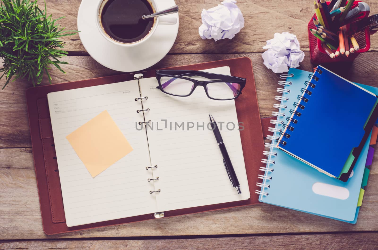 pen, notebook and accessory for work on wooden table