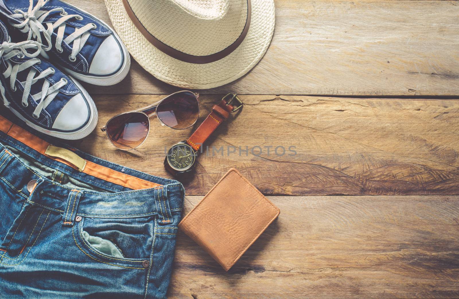 Clothing and accessories for travel on wood floor by photobyphotoboy