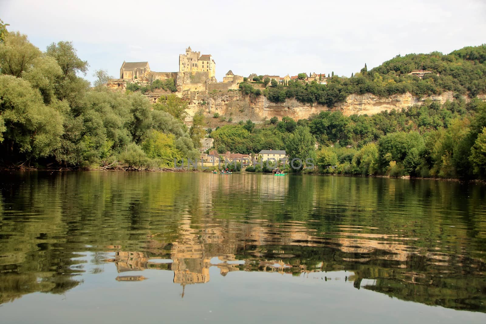 the village of beynac et cazenac with its medieval castle on the cliff reflecting in dordogne river 
