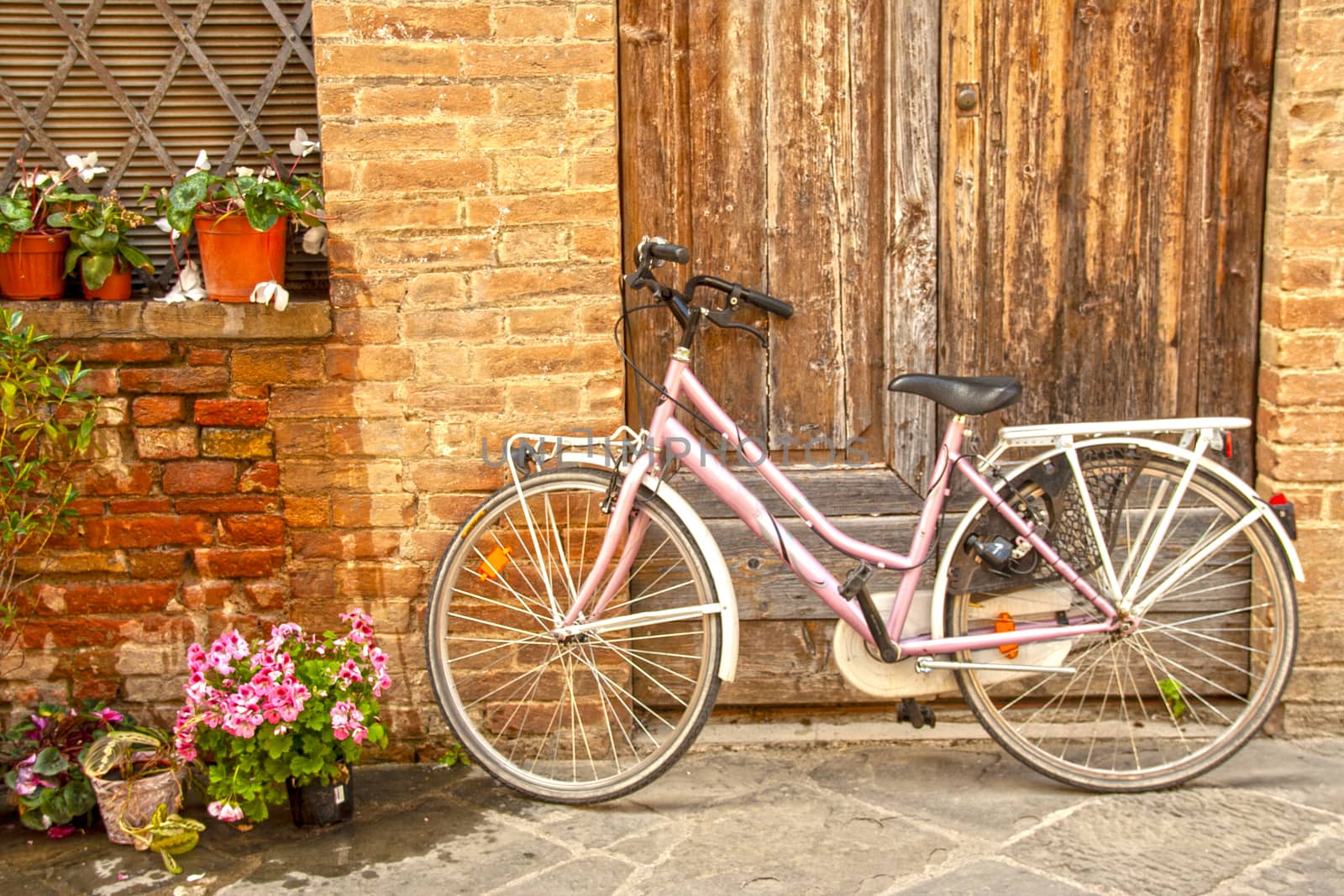 Bicycle on a old brick wall in the medieval city of Buonconvento in Tuscany, one of most beautiful burgs in Italy