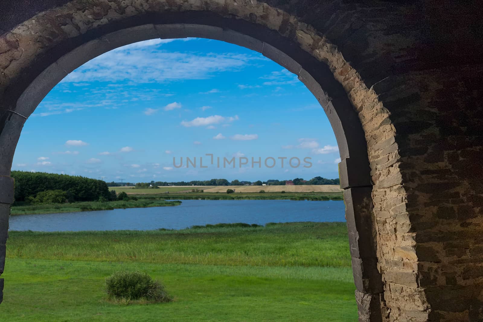 Panoramic view of the swimming, fishing and nature area Eixen lake. Shot looking through a door arch.
