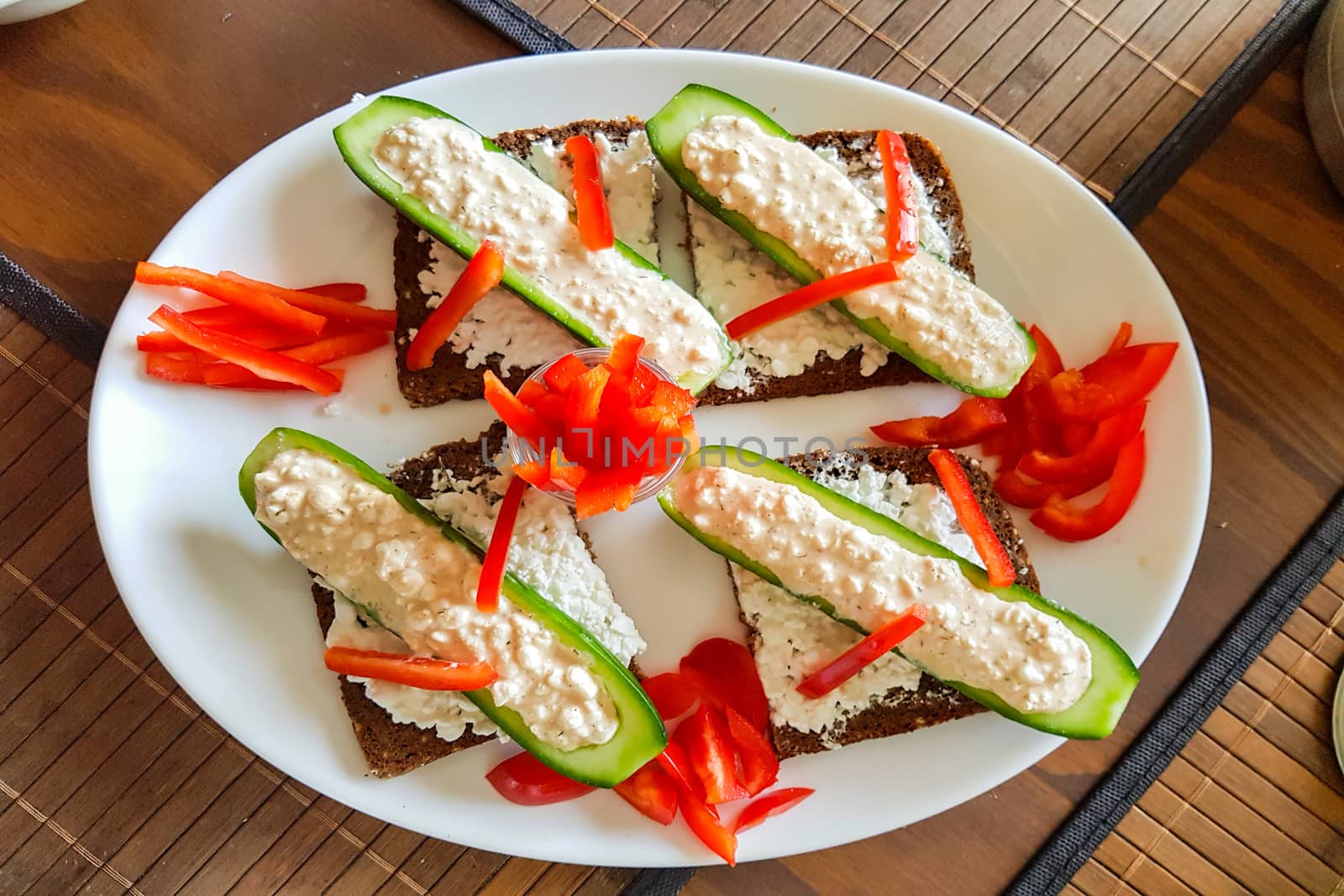 Cucumber boat with fresh quark, pepper strips on black bread     by JFsPic