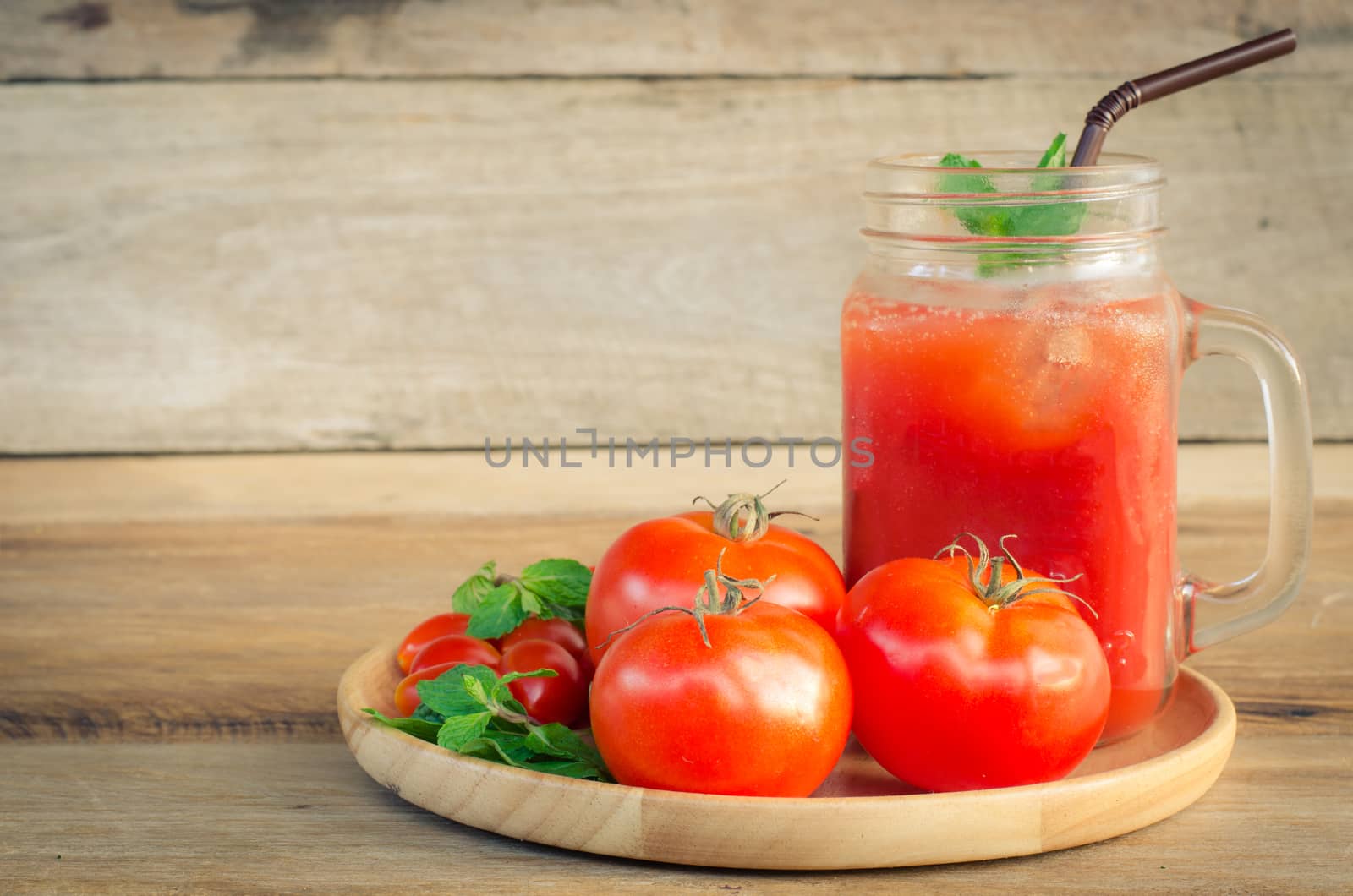 Water tomatoes, red tomatoes on the wood.