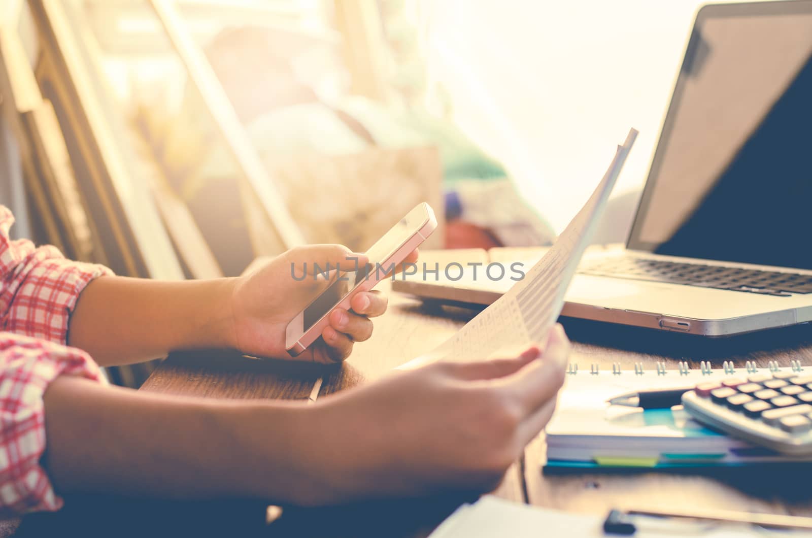 Businessman holding paperwork on the table and analyzing investment chart working in office. Business work concept