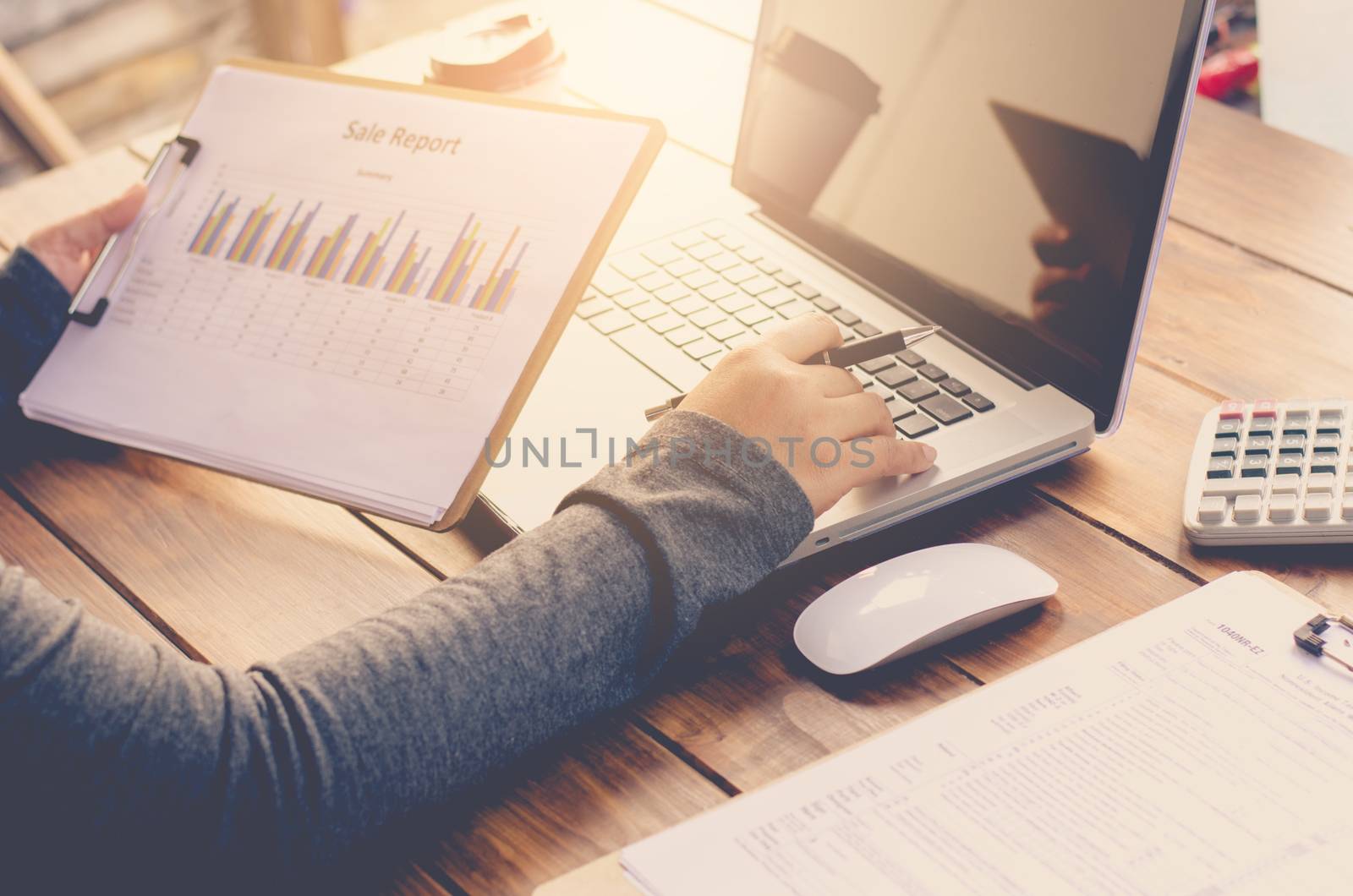Businessman holding paperwork on the table and analyzing investment chart working in office. Business work concept