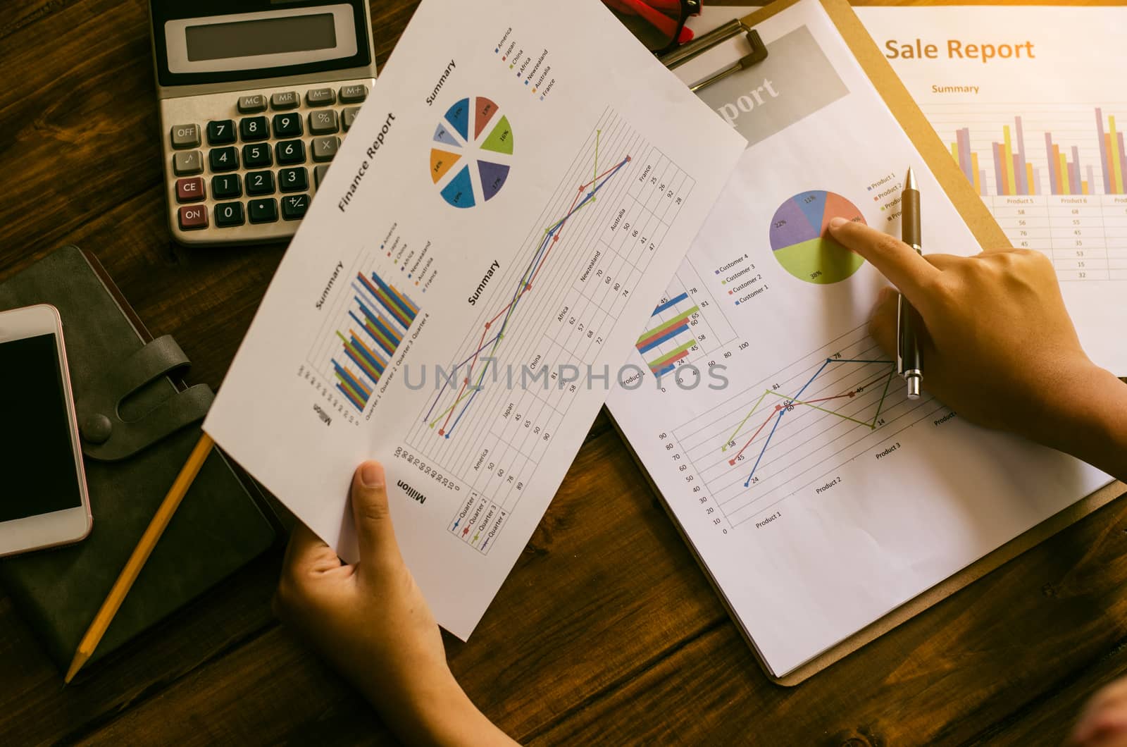 Businessman holding paperwork on the table and analyzing investment chart working in office. Business work concept. 