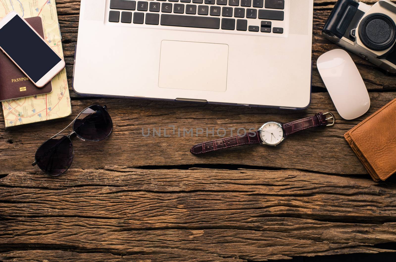 Laptop and travel accessories costumes.Tourism planning and equipment needed for the trip on wooden floor