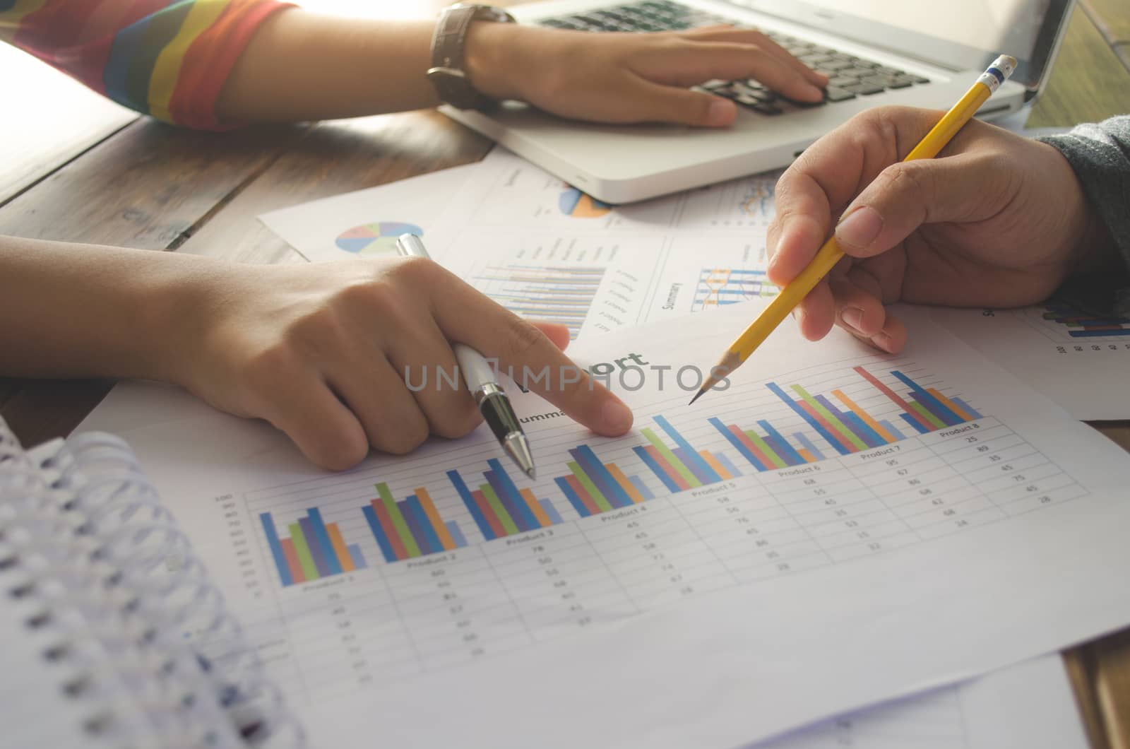 Team business mans job holding paperwork and analyzing investment chart. working with laptop in open space office. Meeting report in progress. sun glare effect