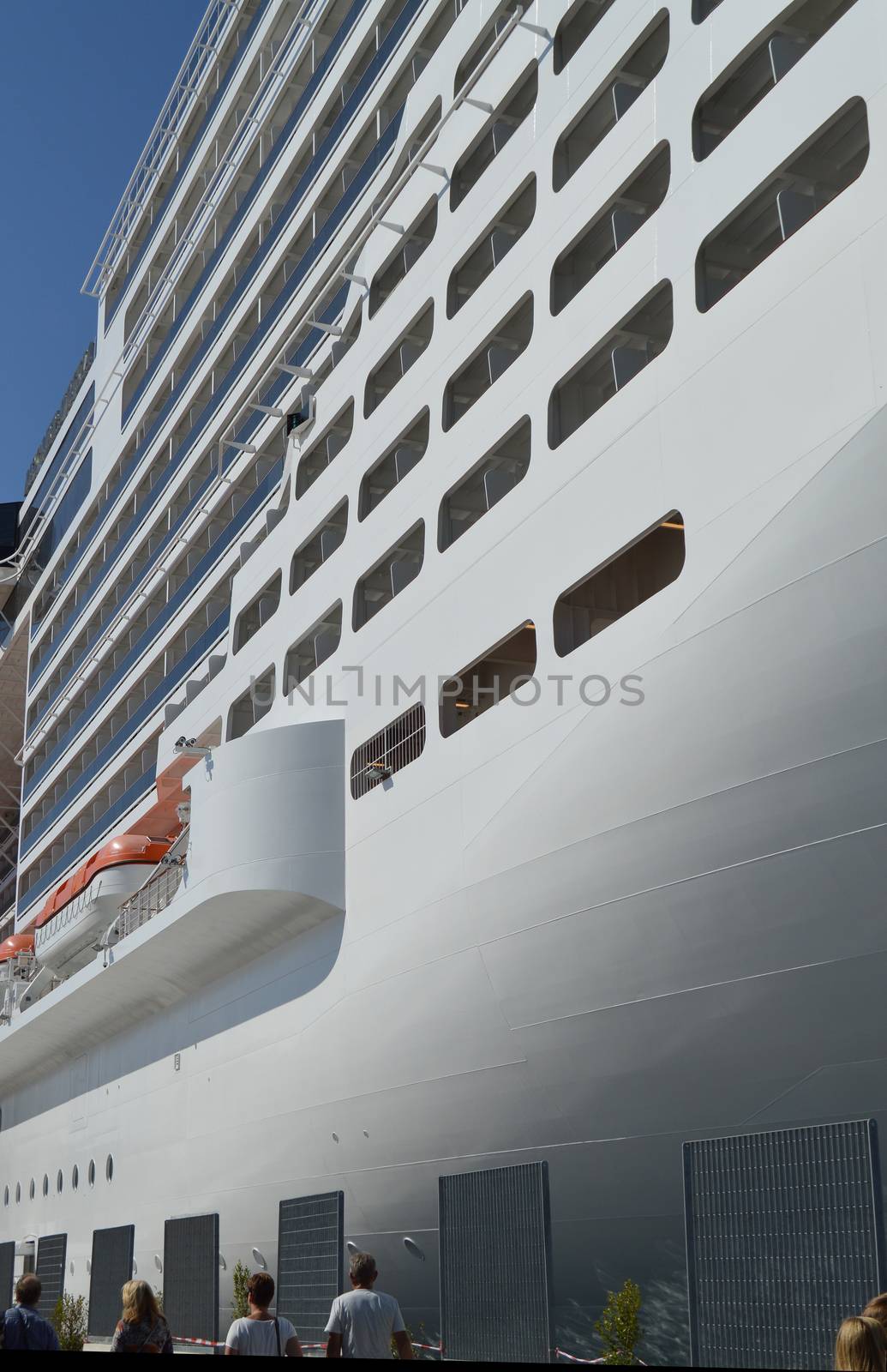 Luxury white cruise ship on blue sky background close-up.