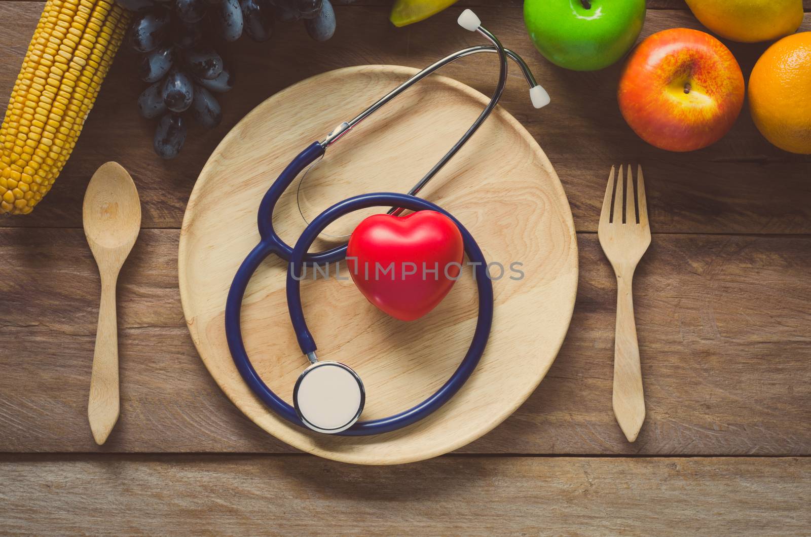 Healthy concept, fruit and ear doctor on wood background