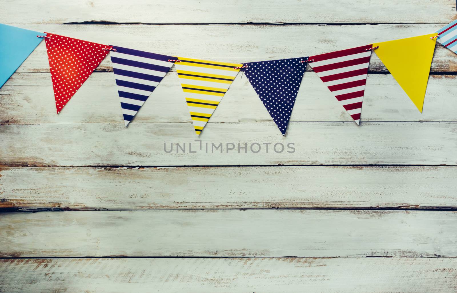 The colorful flag line decorating the banquet has white wooden floor as background.