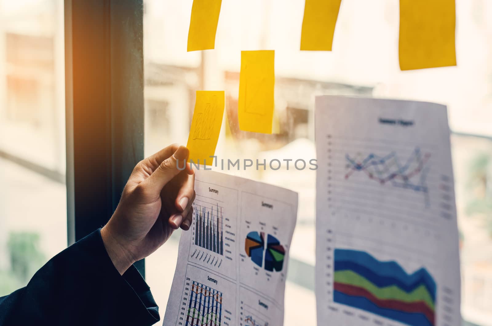 The hand is holding a notepad attached to the glass to see what should be done on the note.