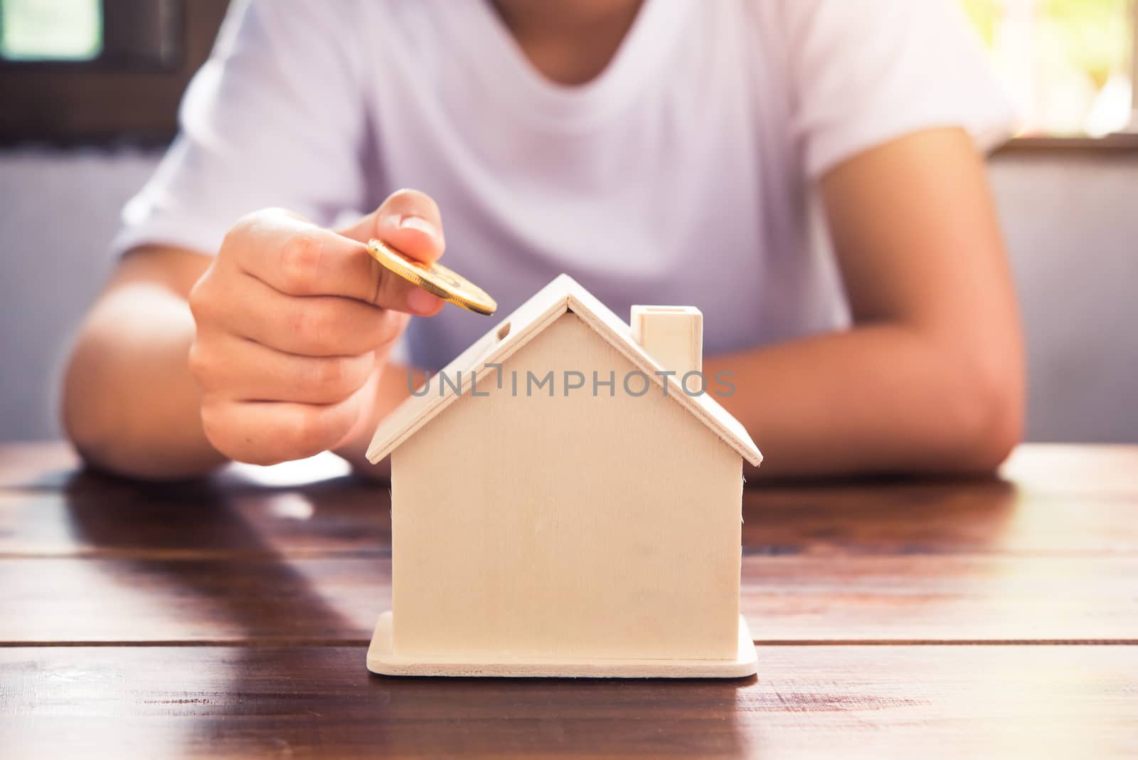 Woman's hand is picking for coin up to drop into a piggy bank - Concept of saving money for the future