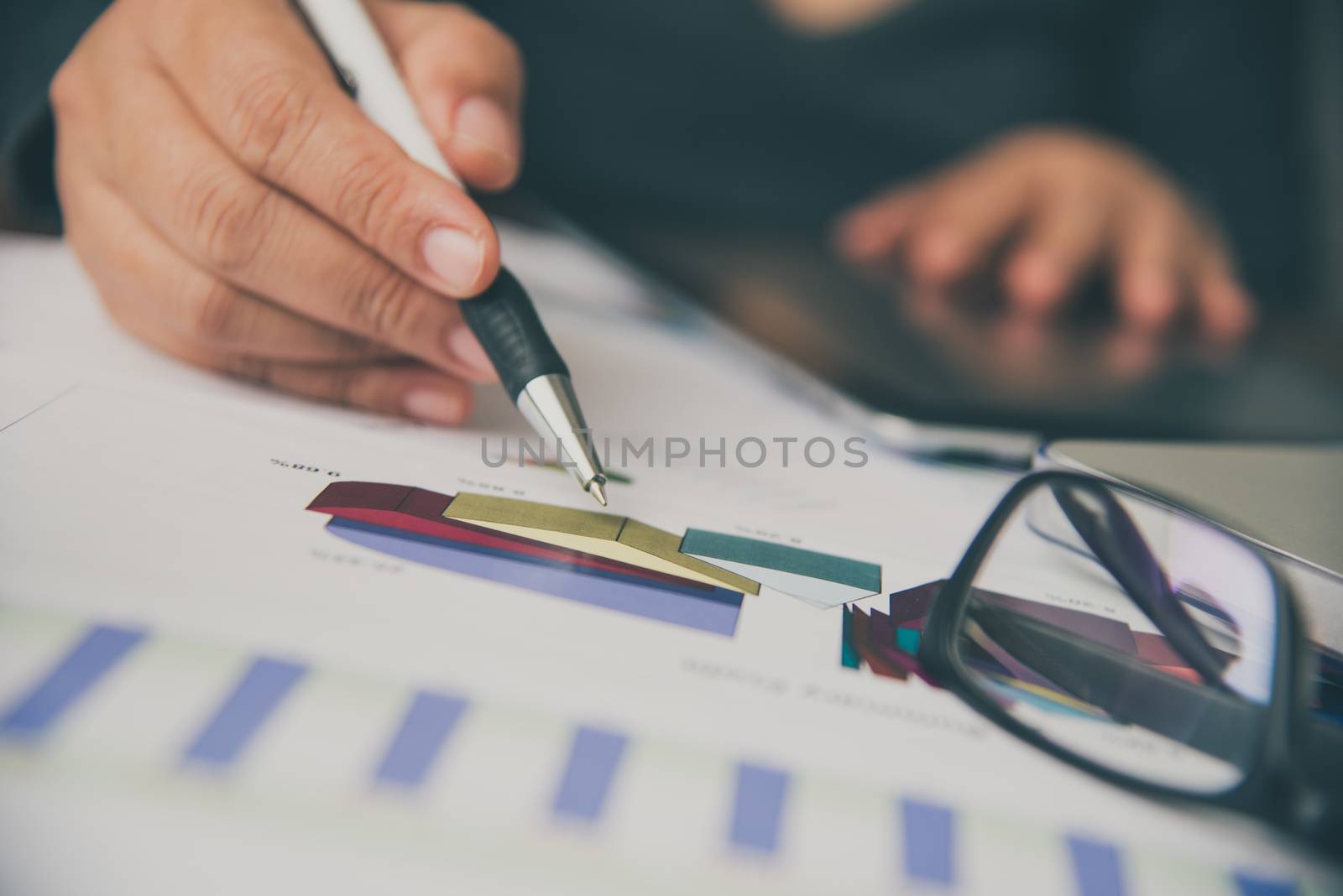 Business people are working on accounts in business analysis with graphs and documentation.