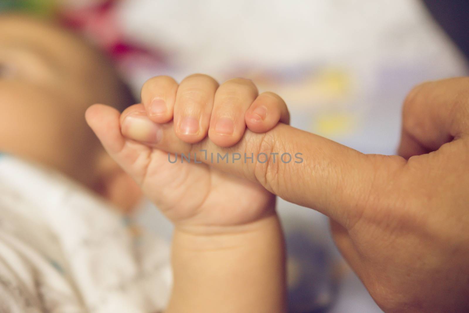 The hands of the mother  hold the baby's hand with love and caring.