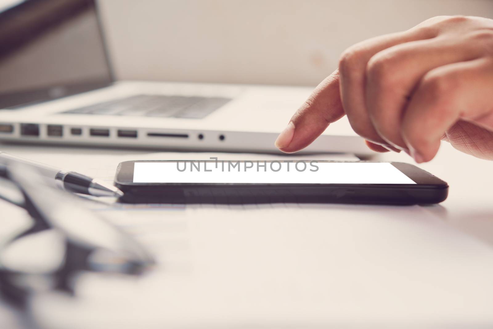 hands holding blank screen mobile in desk work.