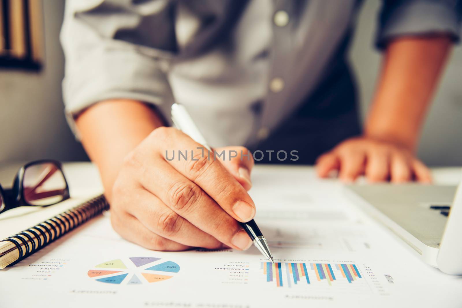 Business people are working on accounts in business analysis with graphs and documentation.