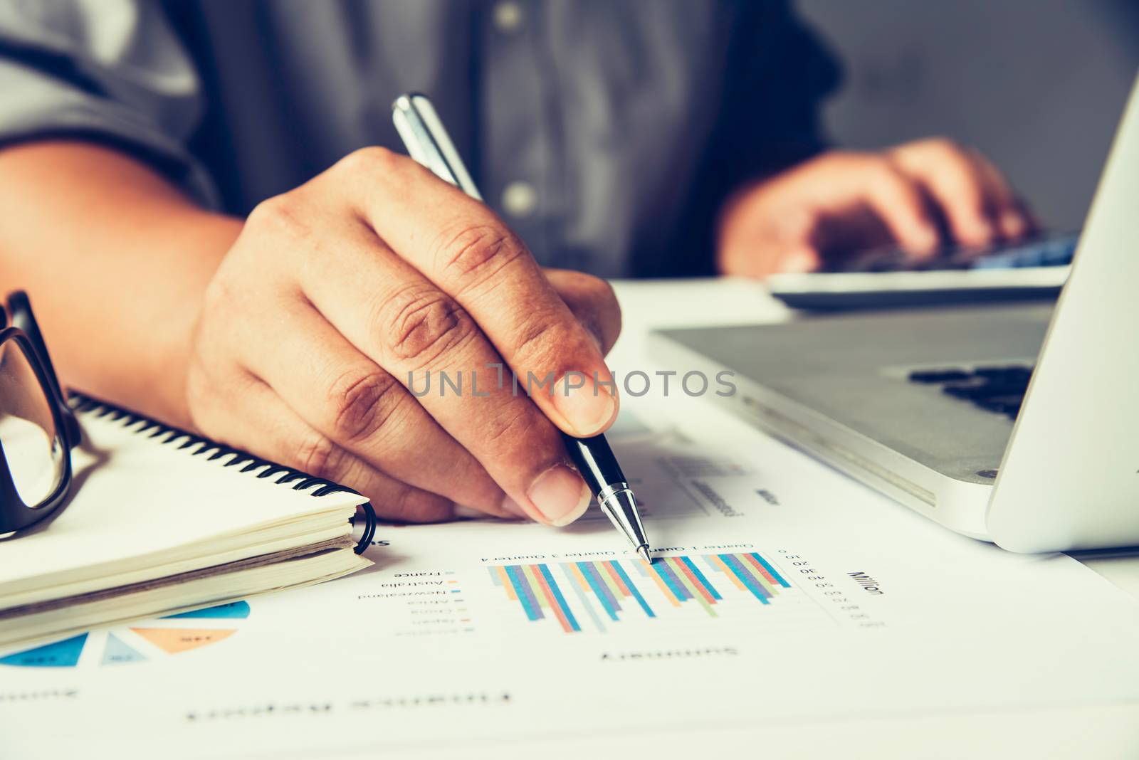 Business people are working on accounts in business analysis with graphs and documentation.