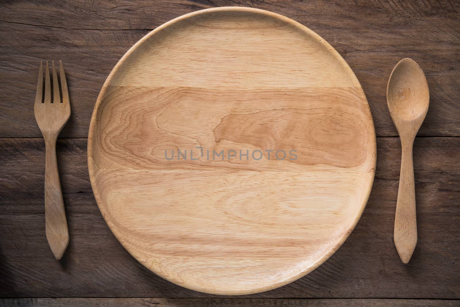 empty wooden dish , fork and spoon on wooden background