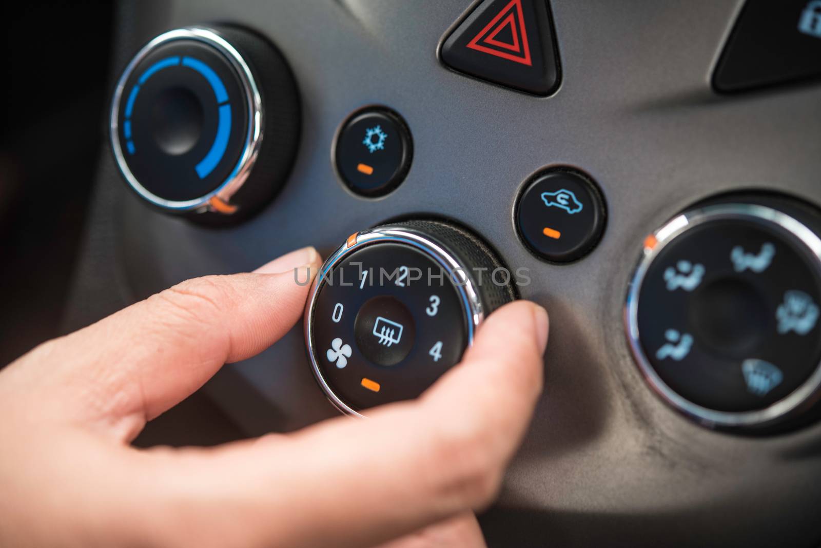 Hand opening the air conditioner in the car.