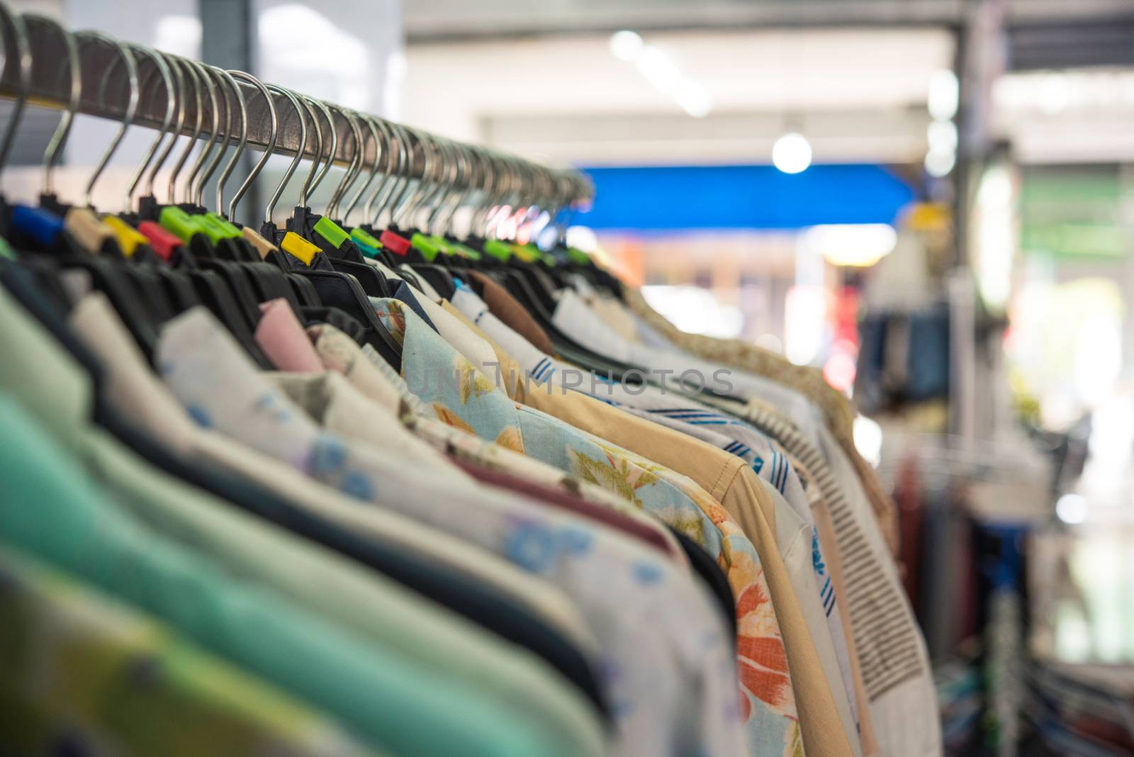 clothes hanging on wooden hangers in a fashion store.