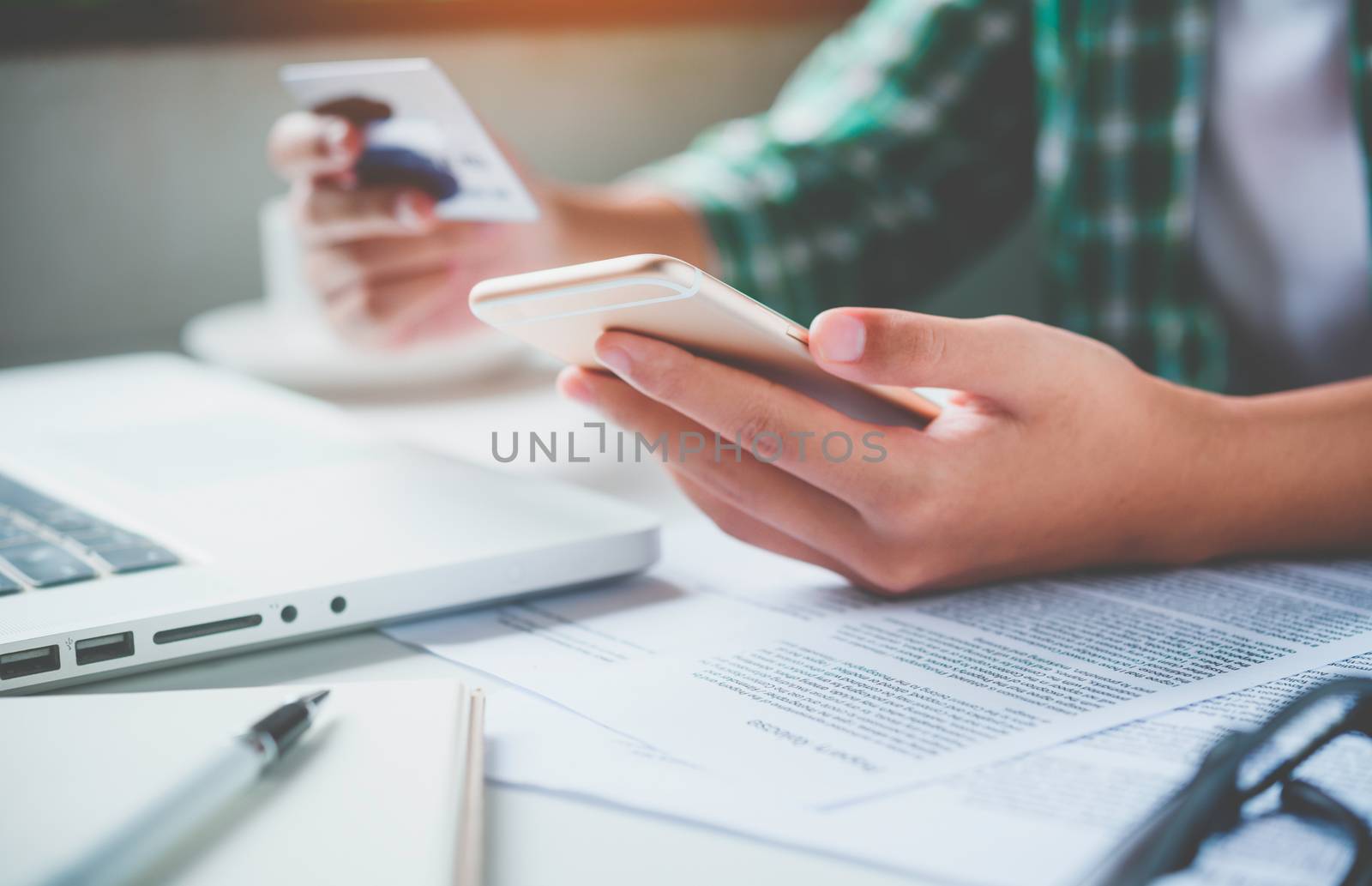 Online payment, hands holding a credit card and using smart phone for online shopping,
Online financial transactions