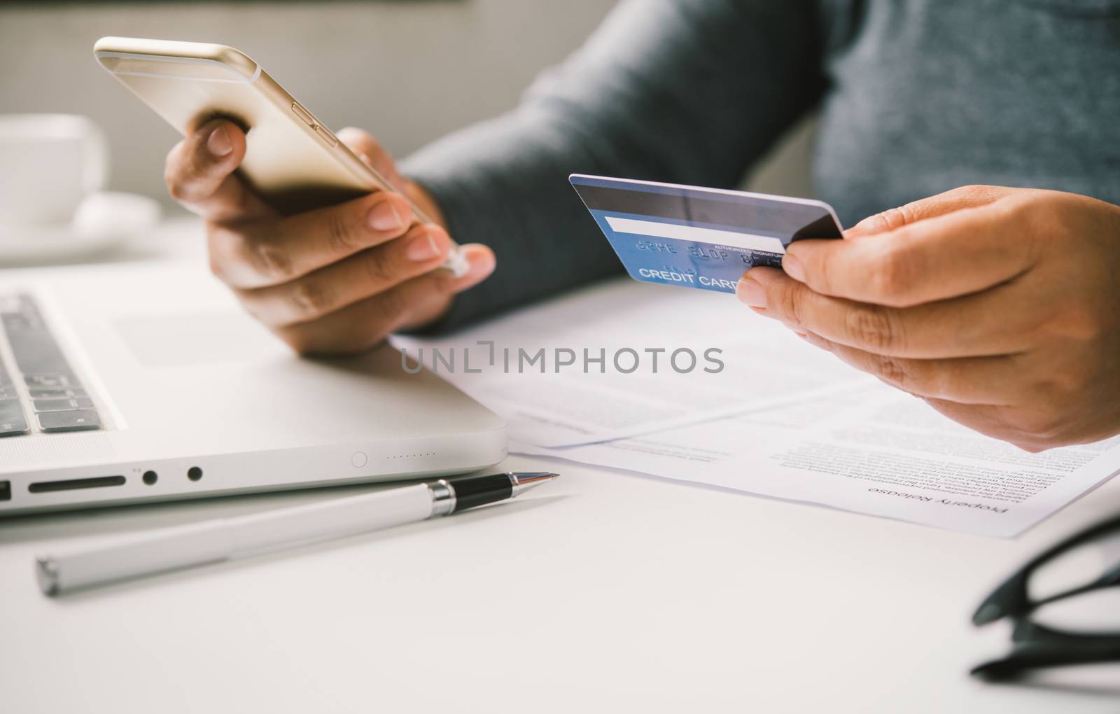 Online payment, hands holding a credit card and using smart phone for online shopping,
Online financial transactions