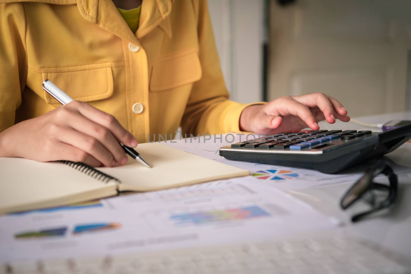 Businesswoman a working on accounts in business analysis with graphs and documentation.