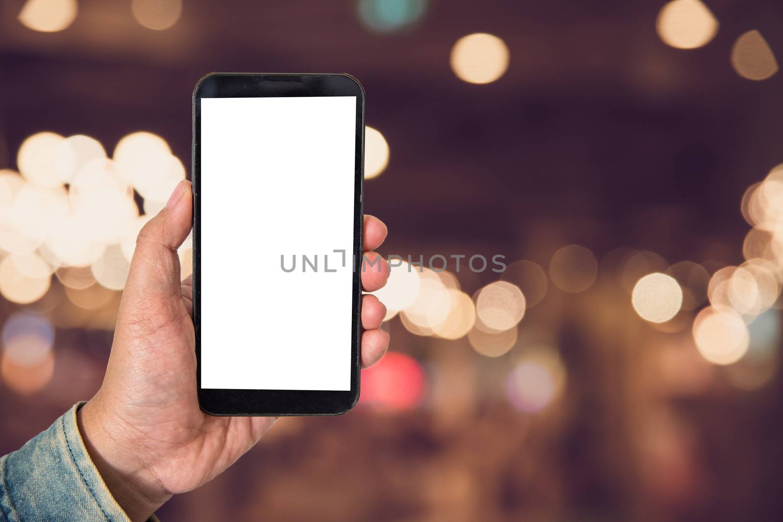 Mock up Blank screen smartphone in shopping mall background of blur background blurred indoors for lifestyle concept or co-working background.