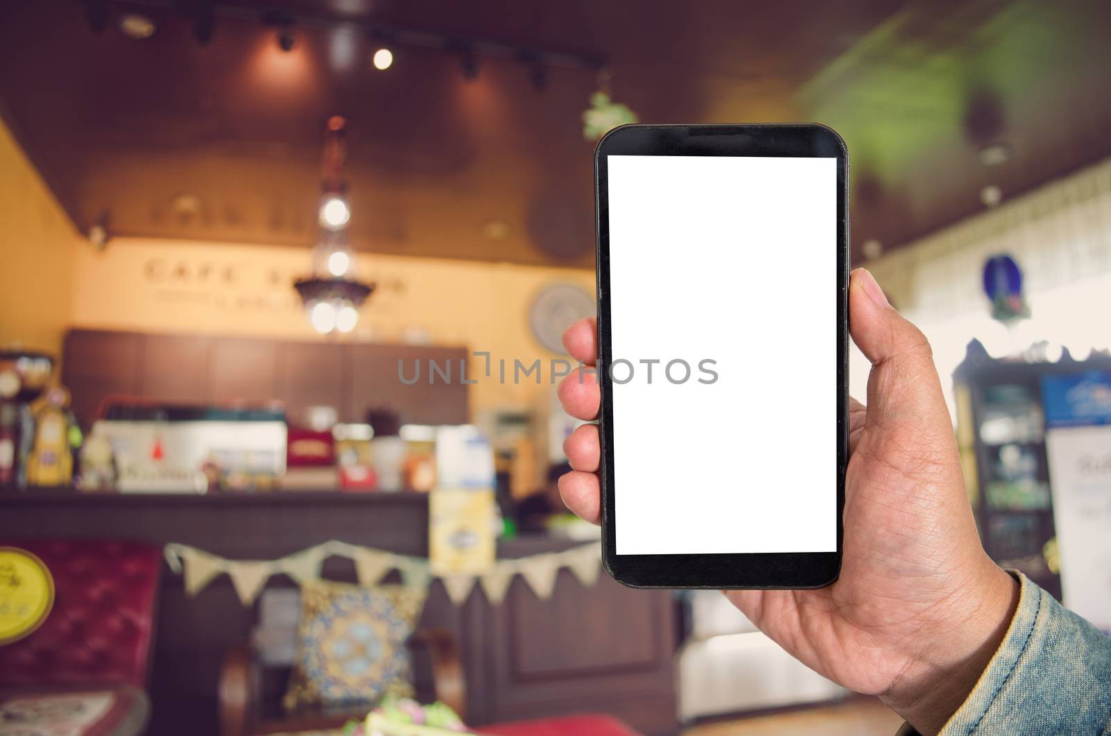 Mock up Blank screen smartphone in shopping mall background of blur background blurred indoors for lifestyle concept or co-working background.