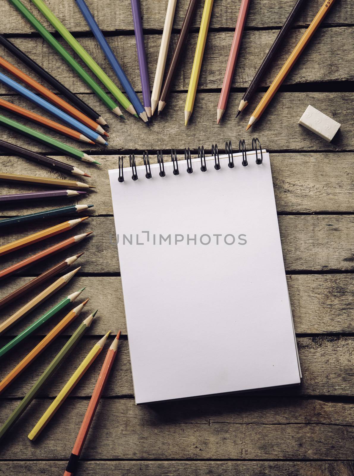 Color pencil and sketchbook on wood background. by photobyphotoboy