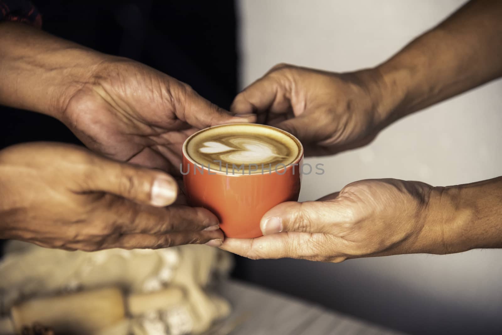 Barista's hands are delivering coffee to customers.