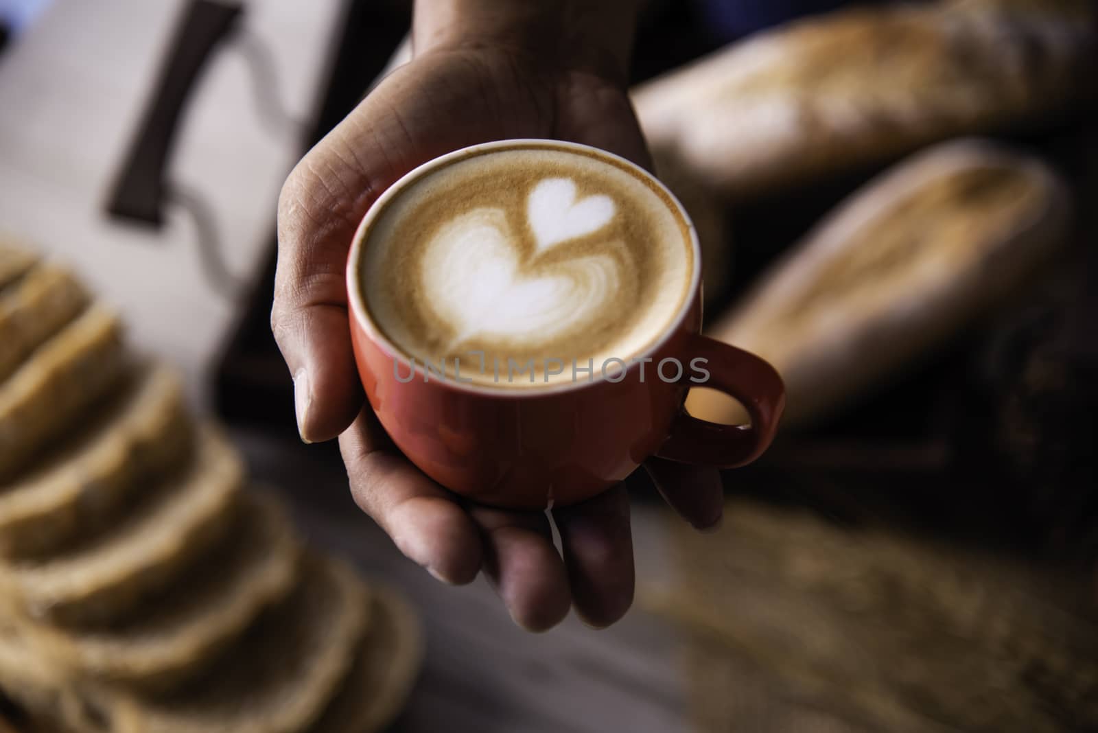 Barista's hands are delivering coffee to customers.